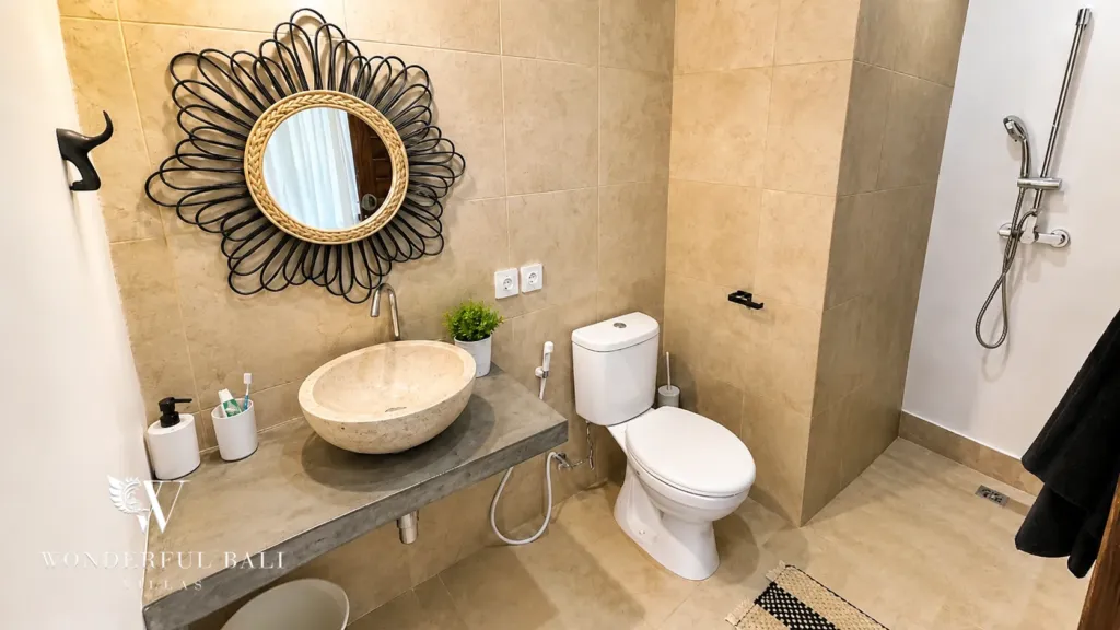 3BR villa for rent in Umalas — bathroom 2, walk-in shower and stone basin under a sunburst mirror