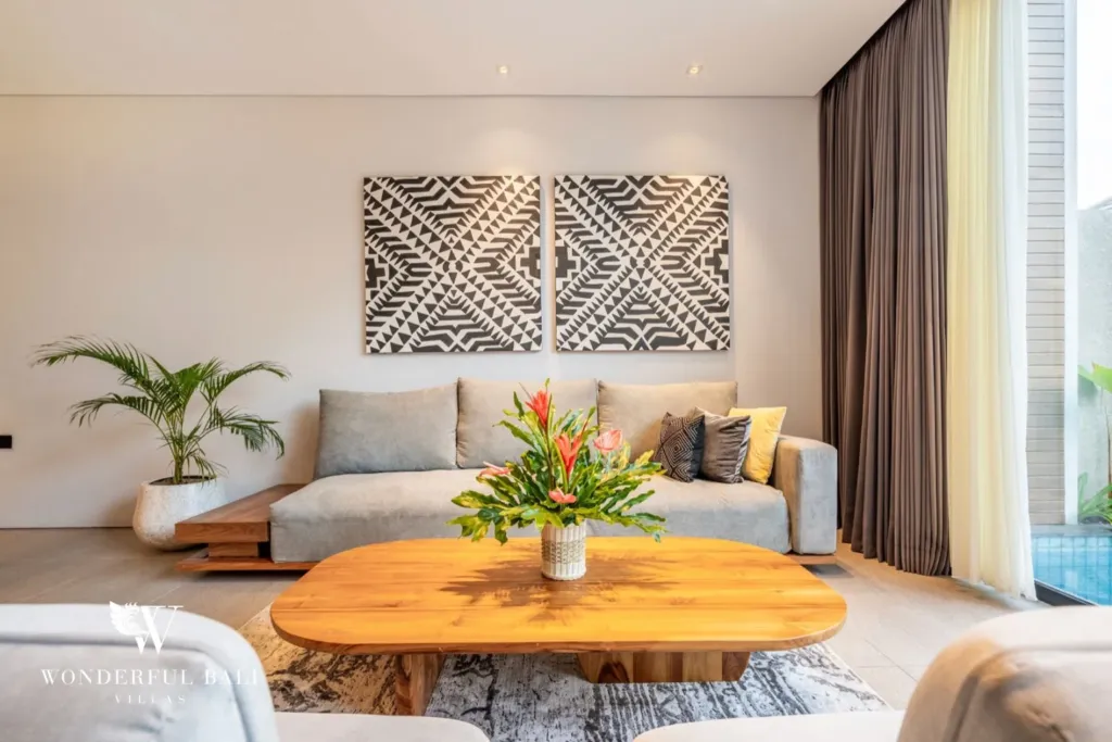3BR villa for rent in Seminyak — living room, sofa and oval timber table under a woven artwork