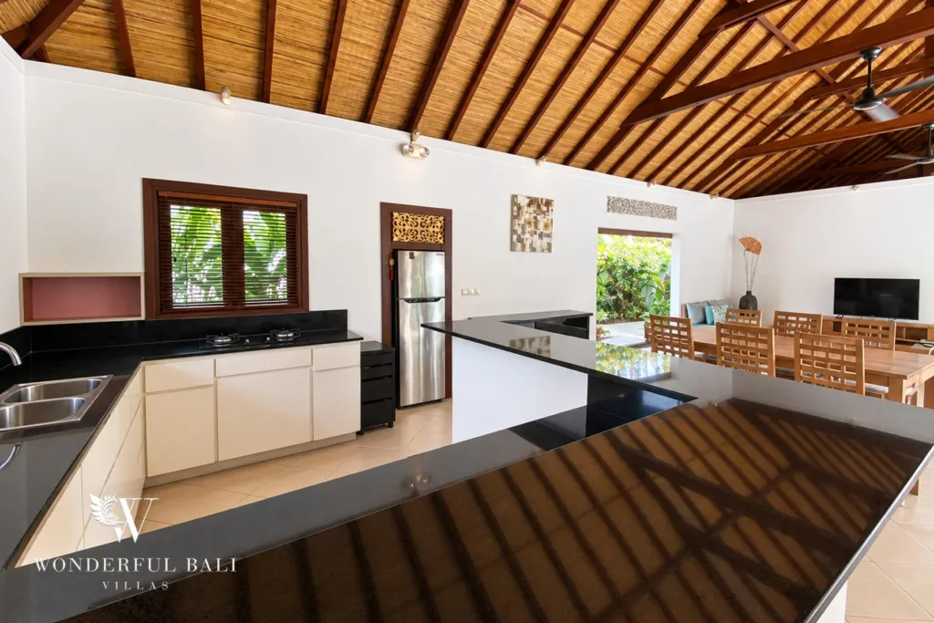 3BR villa for rent in Padonan, Canggu — kitchen, wide view of the kitchen island open to the dining pavilion
