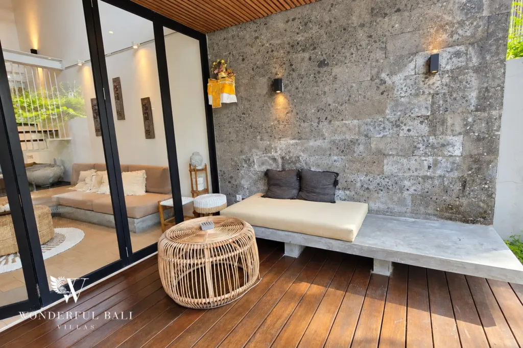 4BR villa for rent in Berawa, Canggu — terrace, timber deck and daybed against a stone wall