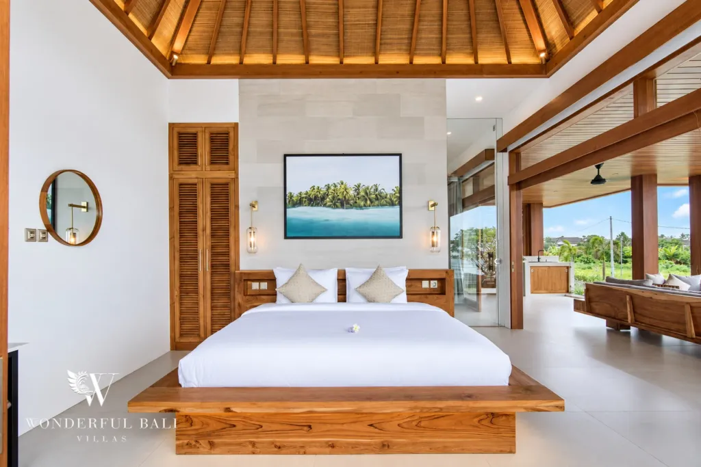 4BR villa for rent in Cemagi — bedroom, teak bed under a vaulted timber roof opening to the lounge