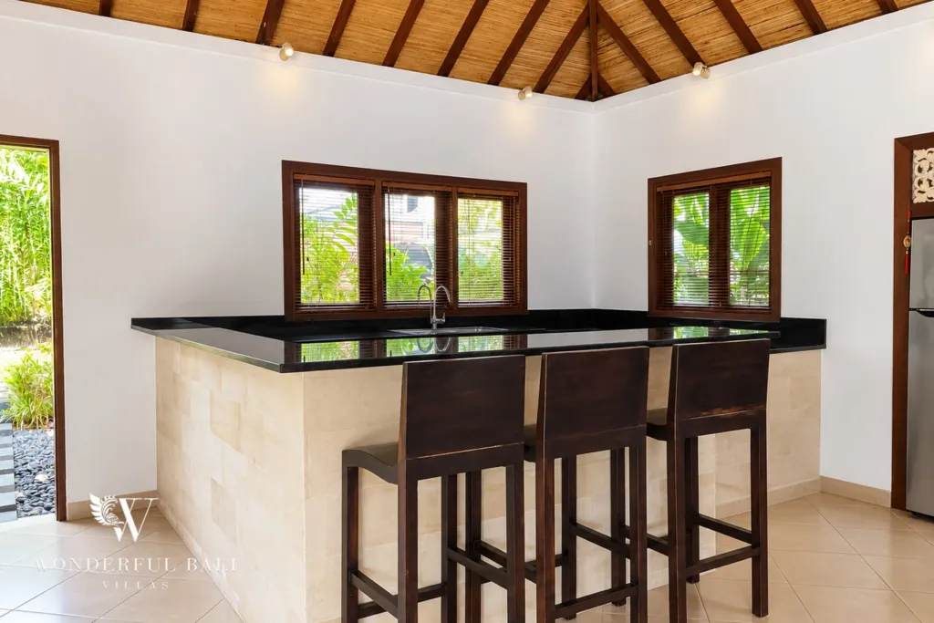 3BR villa for rent in Padonan, Canggu — kitchen, granite breakfast bar with timber stools under the window
