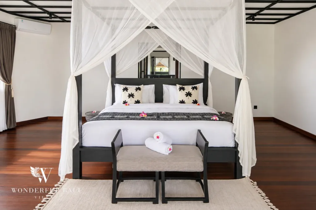 5BR villa for rent in Munggu, Bali — bedroom, four-poster bed with mosquito netting and batik textiles