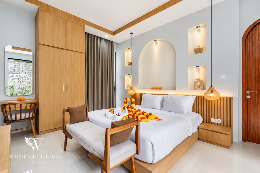 3BR villa for rent in Umalas, Bali — bedroom, double bedroom with a timber bench and arched wall niches