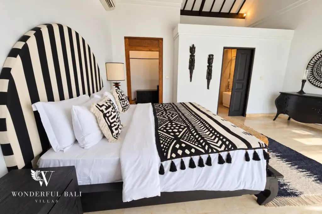 4BR villa for rent in Batu Bolong, Canggu — bedroom, arched black-and-white striped headboard with mudcloth throw