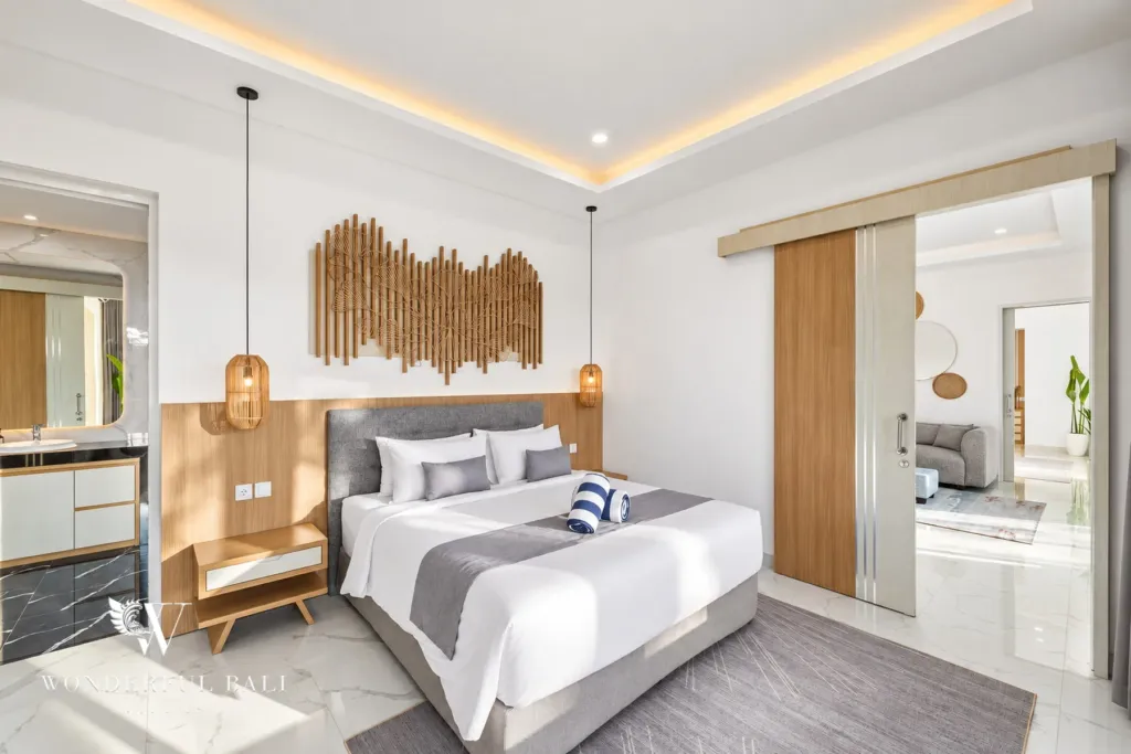 2BR villa for rent in Kaba-Kaba, Bali — bedroom, king bedroom with a carved timber wall panel, opening to the living area