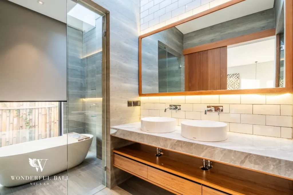 3BR villa for rent in Seminyak — bathroom 1, freestanding tub and twin vanity behind a glass screen