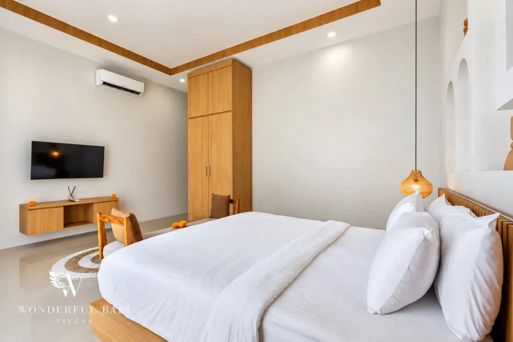 3BR villa for rent in Umalas, Bali — bedroom, wall-mounted TV and timber console opposite the bed
