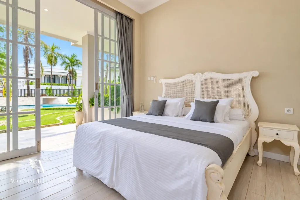5BR villa for sale in Pererenan — bright bedroom with glass doors facing the pool and lawn