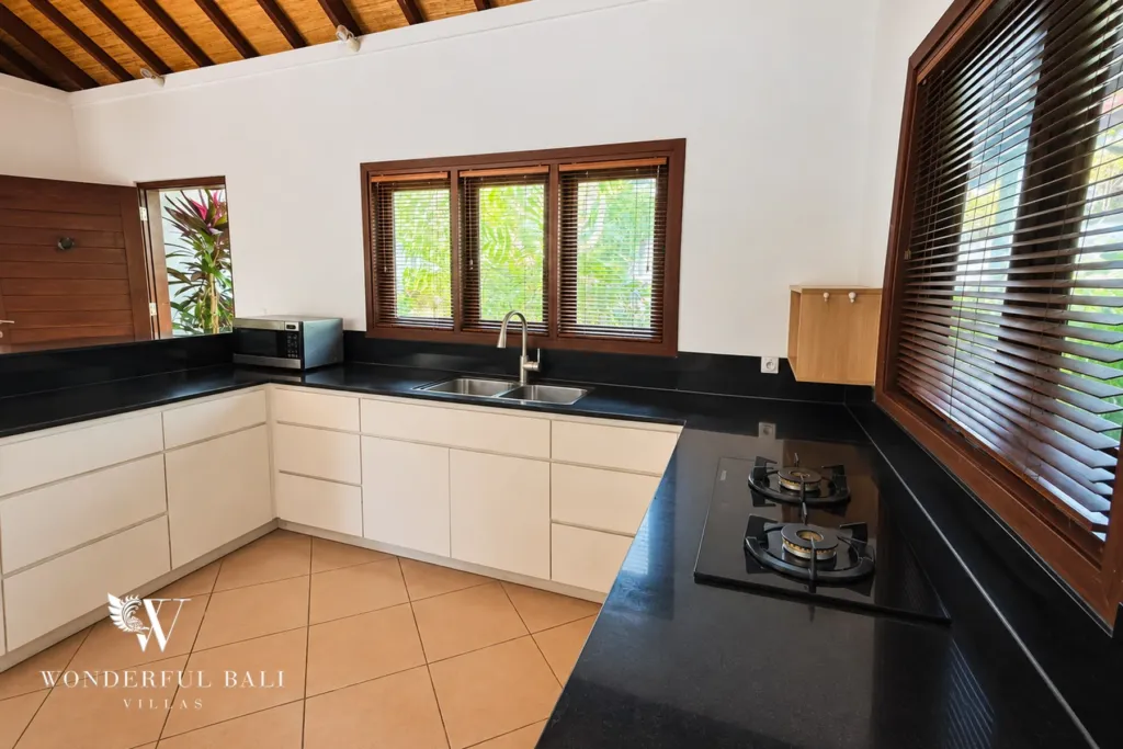 3BR villa for rent in Padonan, Canggu — kitchen, gas hob and sink along the granite counter with louvre door