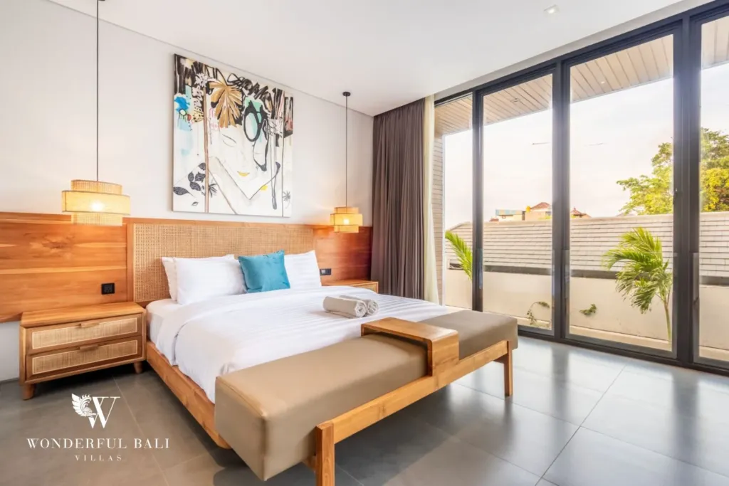 3BR villa for rent in Seminyak — bedroom 2, bed and bench with sliding doors onto the balcony