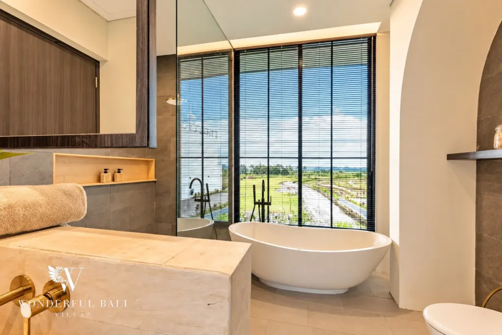 3BR villa for rent in Munggu — ensuite bathroom with bathtub and rice field view