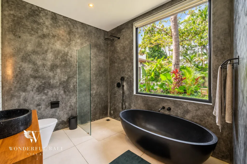 5BR villa for rent in Seseh, Bali — bathroom, stone basin and glazed shower looking into the treetops