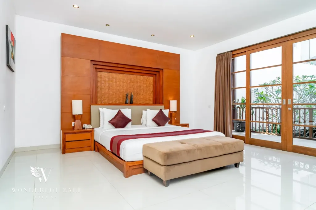 3BR villa for rent in Batu Belig, Seminyak — bedroom, wall-mounted TV and fitted timber wardrobes beside the bed