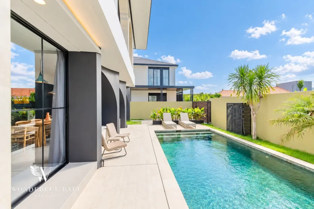 3BR villa for rent in Munggu — poolside terrace with loungers and palms