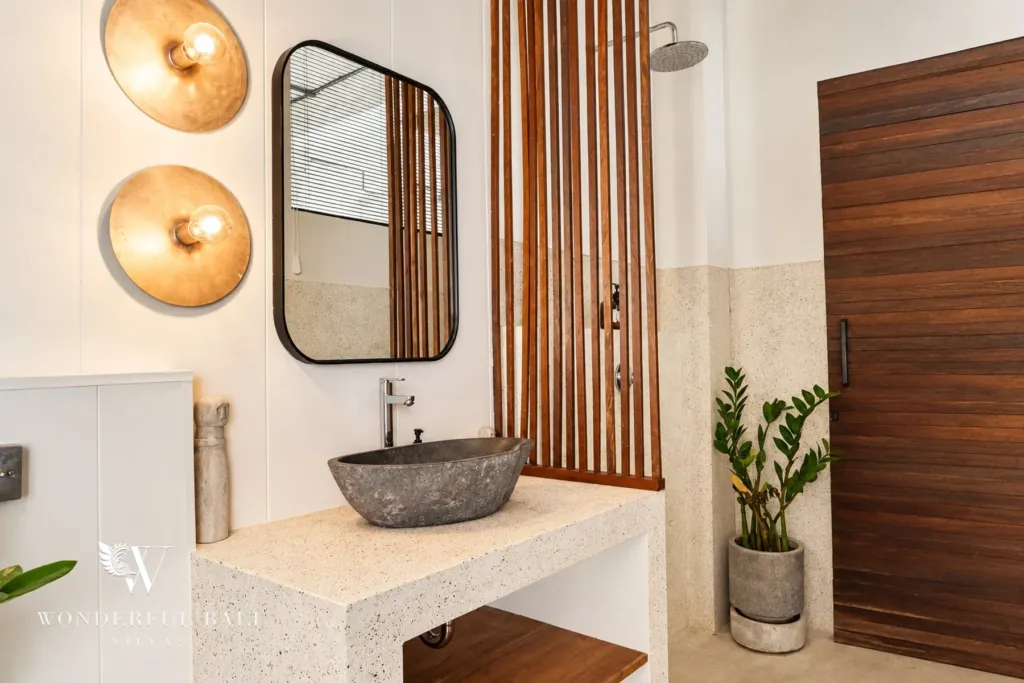 2BR villa for rent in Berawa, Canggu — bathroom, stone basin on a terrazzo vanity with brass wall lights and a mirror
