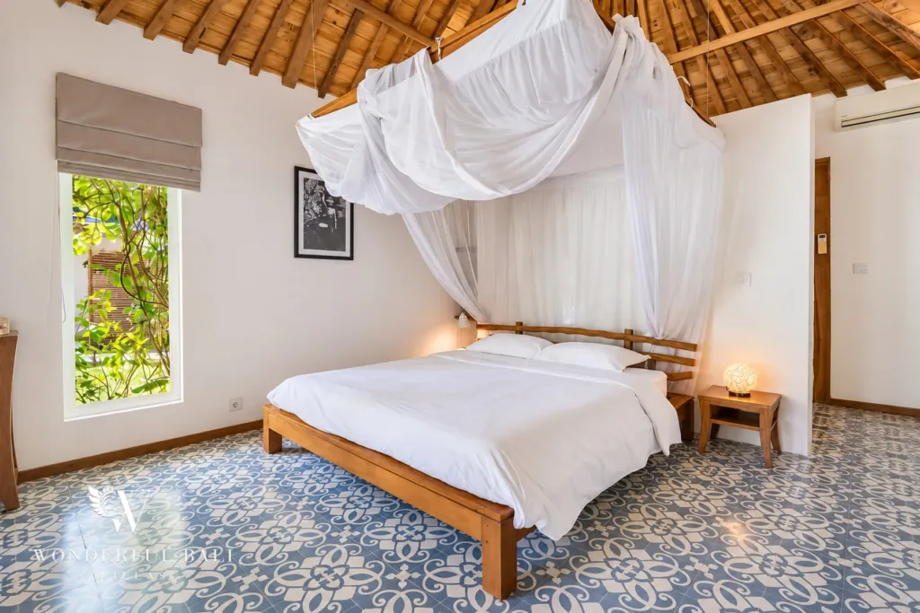 5BR villa for rent in Umalas — bedroom, teak bed with mosquito net and blue patterned floor