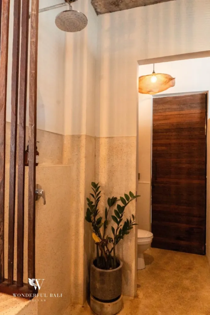 2BR villa for rent in Berawa, Canggu — bathroom, walk-in rain shower in terrazzo with a timber door through to the toilet