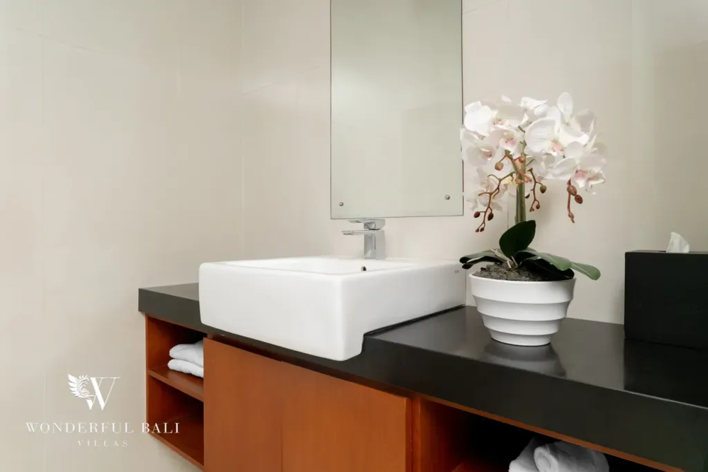 3BR villa for rent in Batu Belig, Seminyak — bathroom, vessel basin on black granite over an open timber vanity