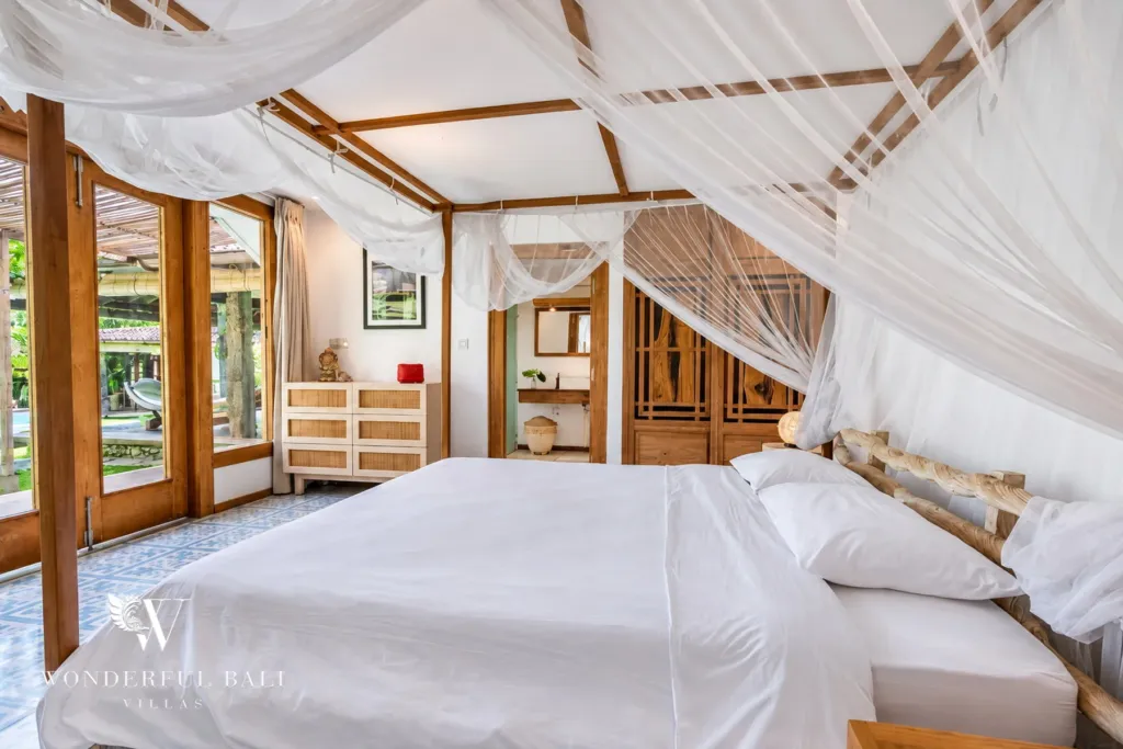 5BR villa for rent in Umalas — bedroom, canopy bed with glass doors opening to the garden