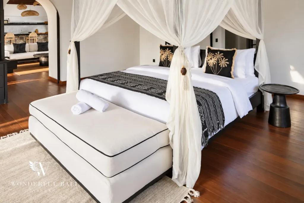 5BR villa for rent in Munggu, Bali — bedroom, side view of the canopy bed with woven wall discs above