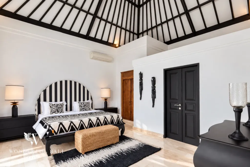 4BR villa for rent in Batu Bolong, Canggu — bedroom, wide view of the striped-headboard bedroom and seating