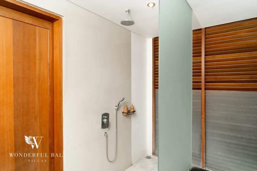3BR villa for rent in Batu Belig, Seminyak — bathroom, walk-in rain shower beside timber louvre screens