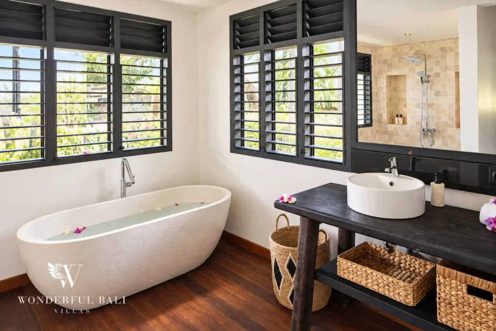 5BR villa for rent in Munggu, Bali — bathroom, freestanding stone bathtub beside a timber vanity and louvre windows