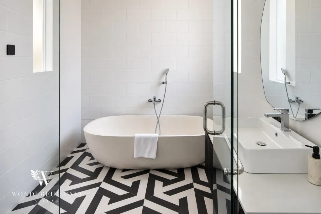 5BR villa for rent in Munggu, Bali — bathroom, freestanding tub on graphic monochrome floor tiles