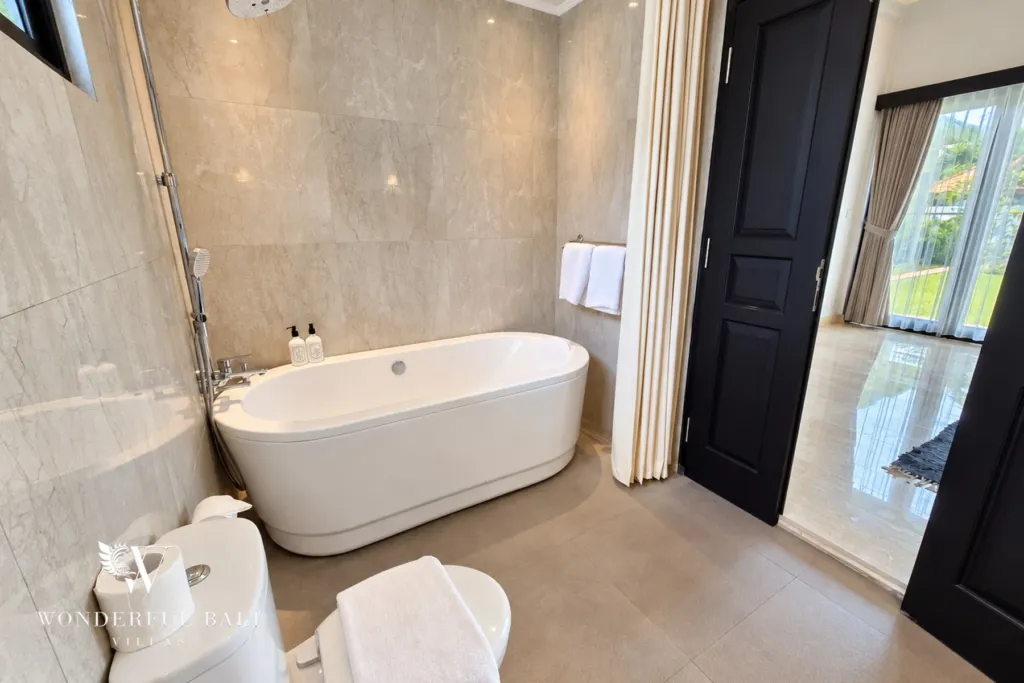 4BR villa for rent in Batu Bolong, Canggu — bathroom, freestanding tub beside black double doors to the bedroom
