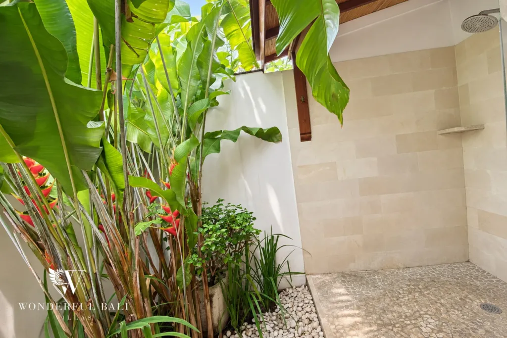 3BR villa for rent in Padonan, Canggu — bathroom, open-air rain shower against a planted wall on pebble flooring