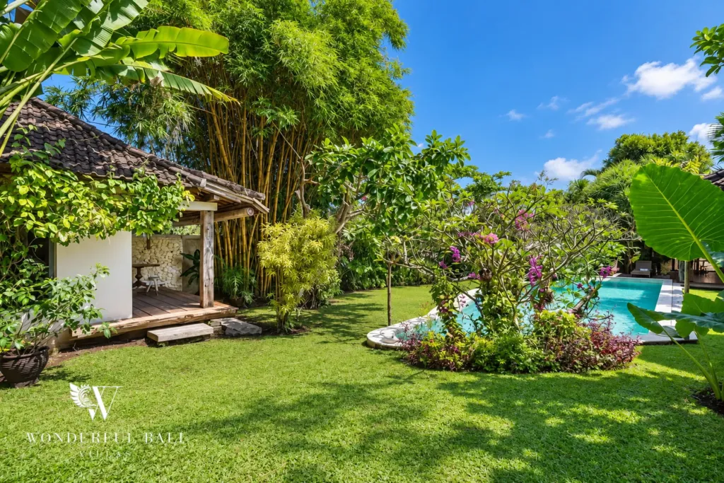 5BR villa for rent in Umalas — garden, large lawn with bamboo, flowering trees and the pool beyond