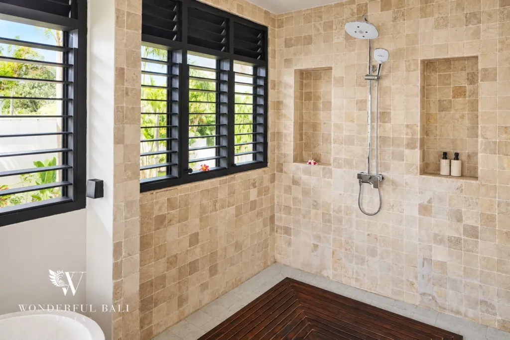 5BR villa for rent in Munggu, Bali — bathroom, walk-in rain shower in stone tiling with a recessed niche