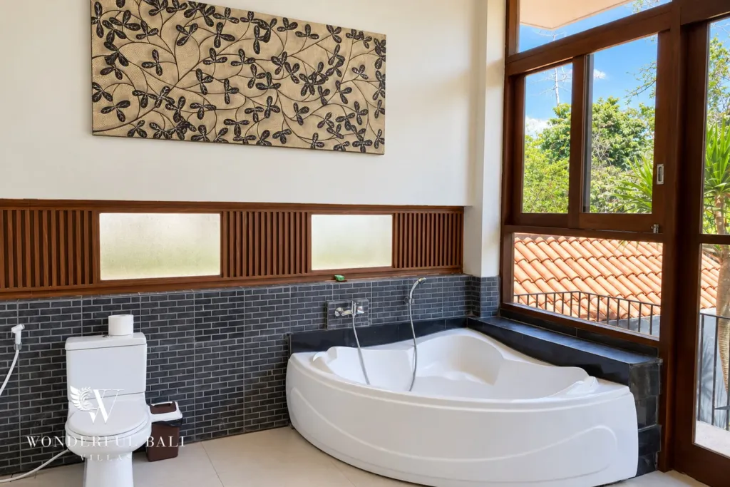 3BR villa for sale in Jimbaran — bathroom, corner bathtub beside a window over the garden