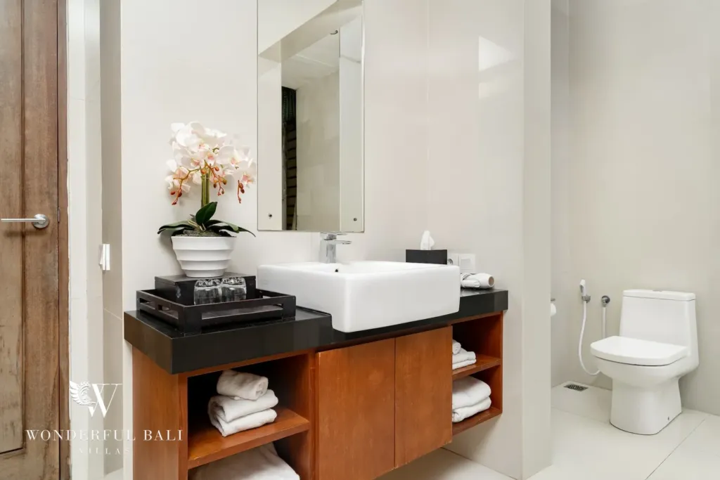 3BR villa for rent in Batu Belig, Seminyak — bathroom, vessel basin on black granite with open timber shelving below