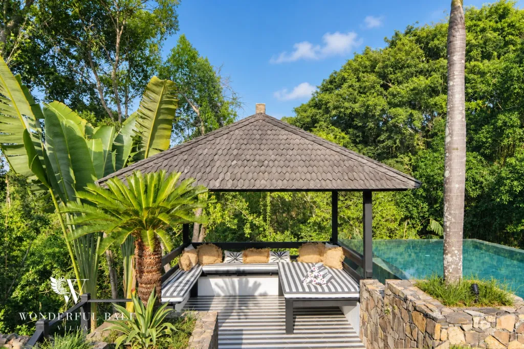 5BR villa for rent in Munggu, Bali — pool, thatched pavilion with daybeds at the head of the pool