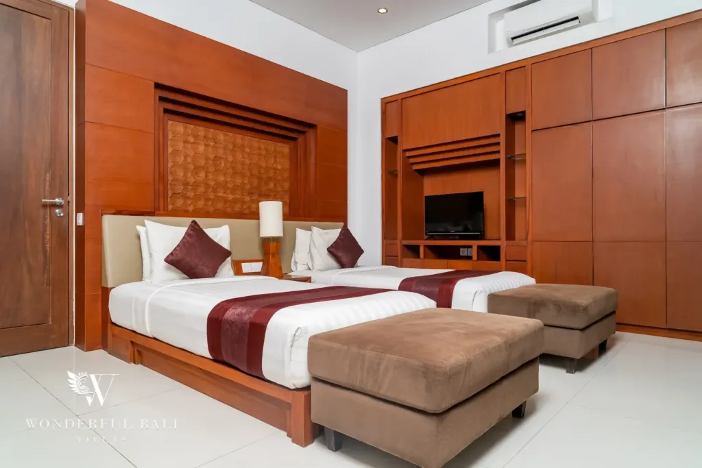 3BR villa for rent in Batu Belig, Seminyak — bedroom, twin beds with fitted timber wardrobes and a wall-mounted TV
