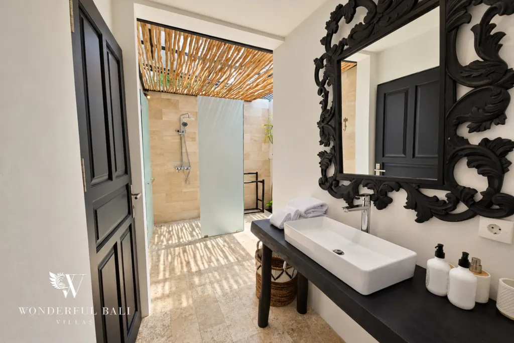 4BR villa for rent in Batu Bolong, Canggu — bathroom, carved black mirror above a vessel basin on a timber console