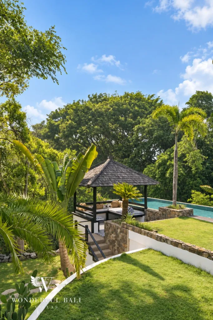 5BR villa for rent in Munggu, Bali — garden, mature palms and lawn running down towards the valley