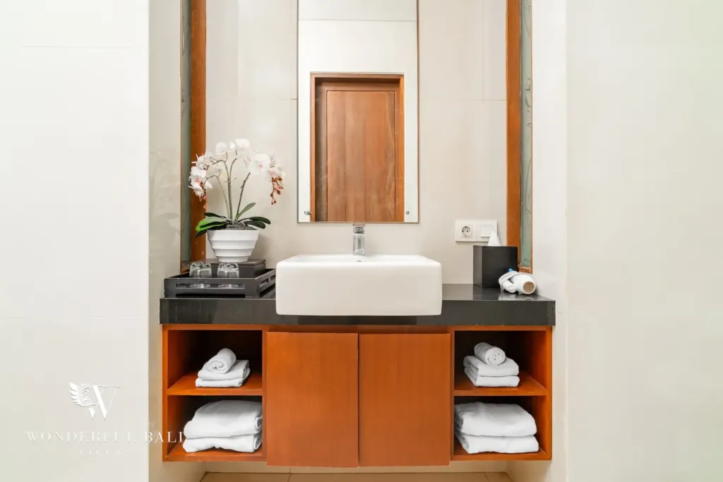 3BR villa for rent in Batu Belig, Seminyak — bathroom, vessel basin on black granite beside the glazed shower