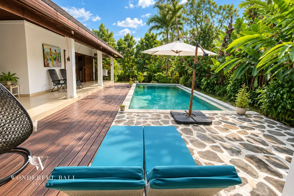 3BR villa for rent in Padonan, Canggu — pool, turquoise loungers and parasol on the stone terrace by the water