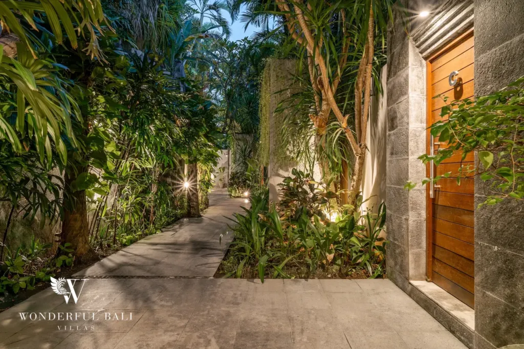 3BR villa for rent in Batu Belig, Seminyak — entrance, lit private path between stone walls and dense planting to the door