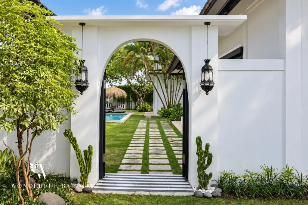 4BR villa for rent in Batu Bolong, Canggu — garden, white arched garden gateway with lanterns and a striped path