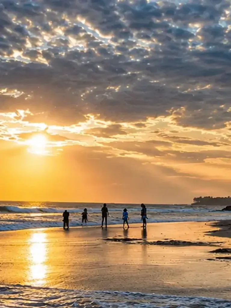 Families on the sand at Pererenan beach, Bali, at sunset