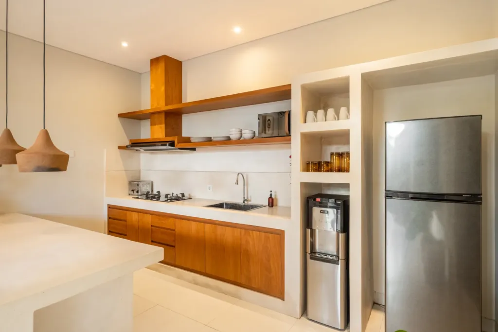 Kitchen with timber cabinetry, gas hob and fridge at Villa Reviva