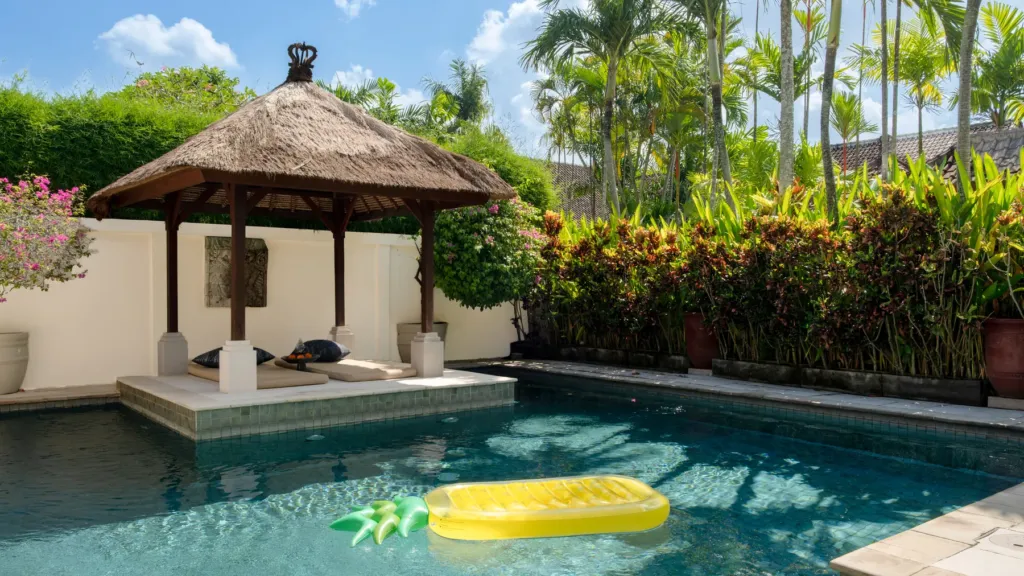 Pool and bale backed by a tropical hedge at Villa V Seminyak