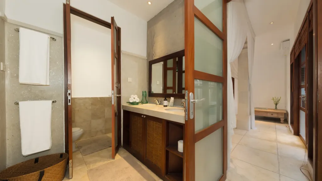 En-suite vanity with fresh towels and a separate WC at Villa V Seminyak
