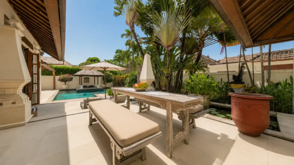 Outdoor dining table and bench beside the pool at Villa V Seminyak