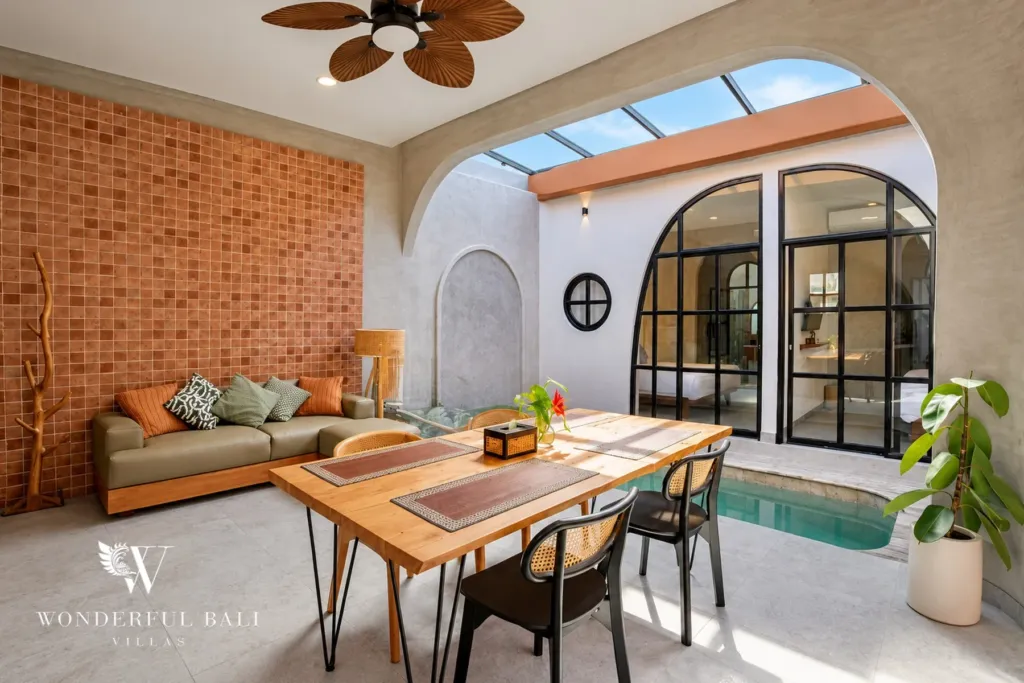 2BR villa for sale in Sanur — open living room, dining table and private pool under arched Mediterranean-style walls