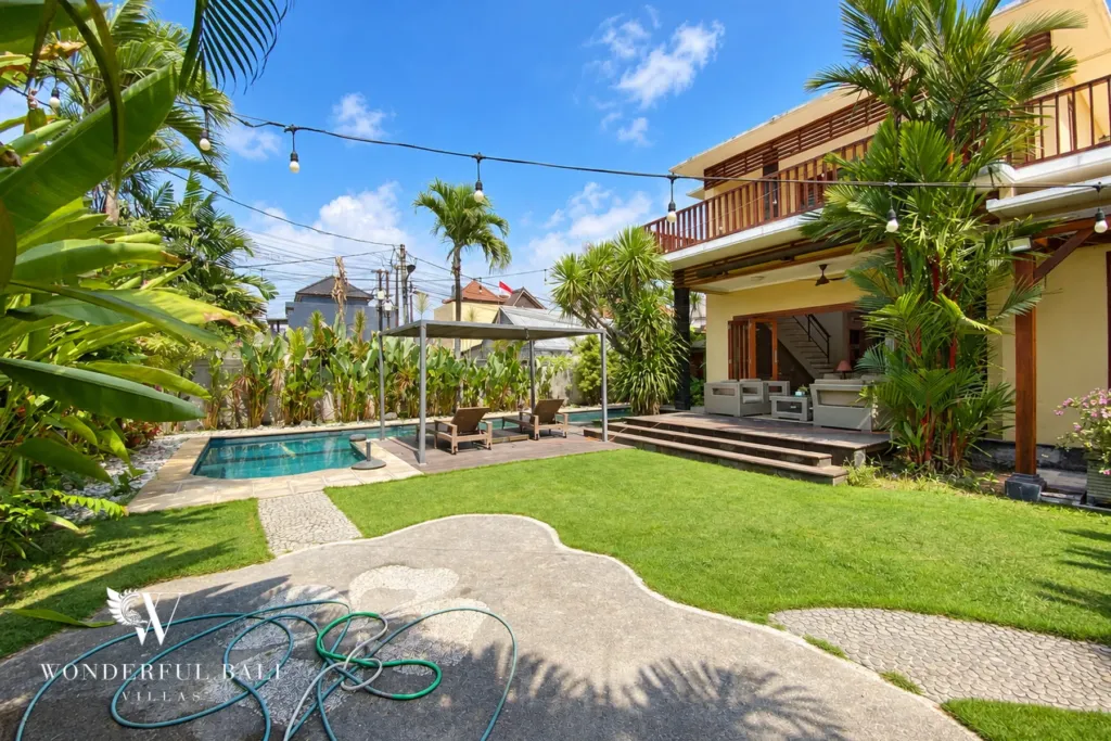 3BR villa for rent in Sanur — large lawn with stepping-stone paths and the pool beyond